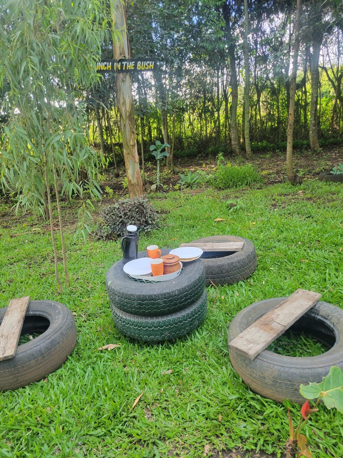 Creative outdoor dining area made from repurposed tires with 'Lunch in the Bush' sign